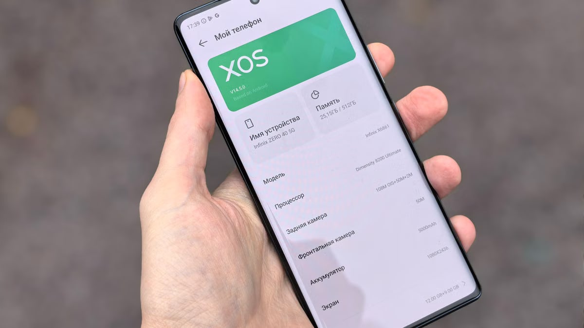 Person holding smartphone showing XOS interface on the screen, captured outdoors.